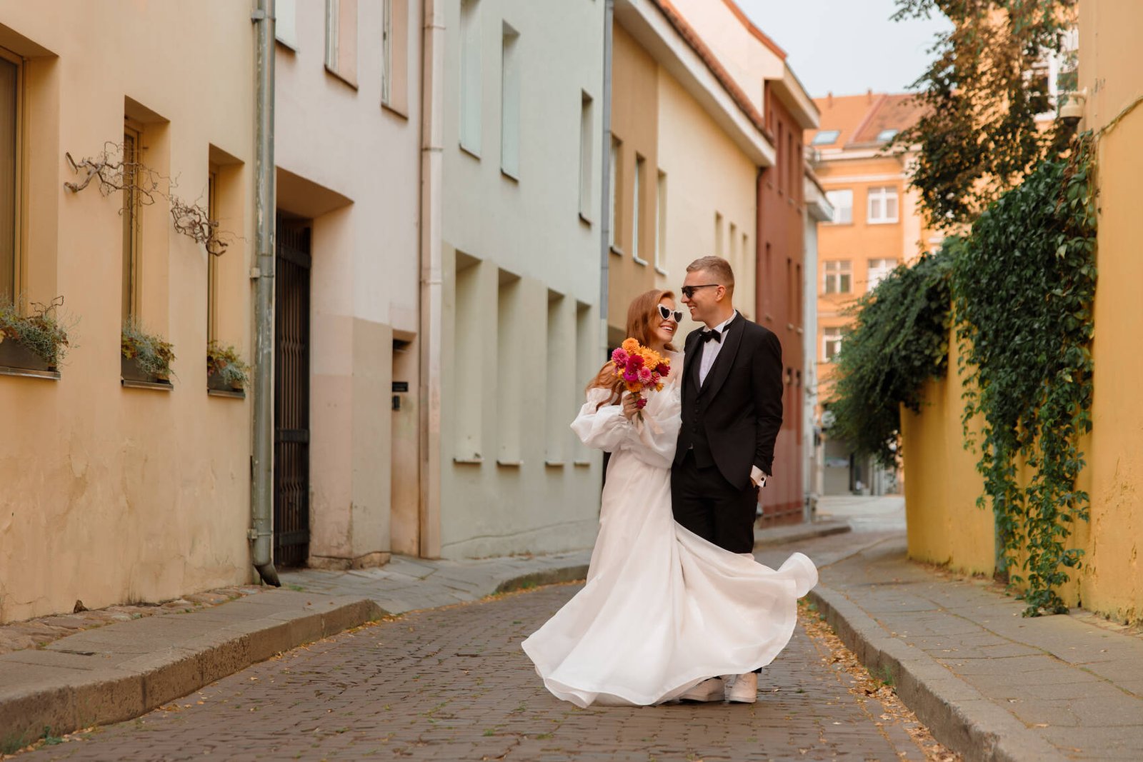 Newlyweds dancing in a cobbled street of Vilnius Old Town
