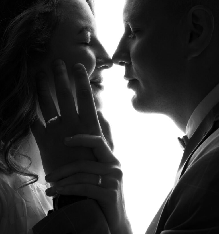 Black and white portrait of a bride and groom almost touching noses