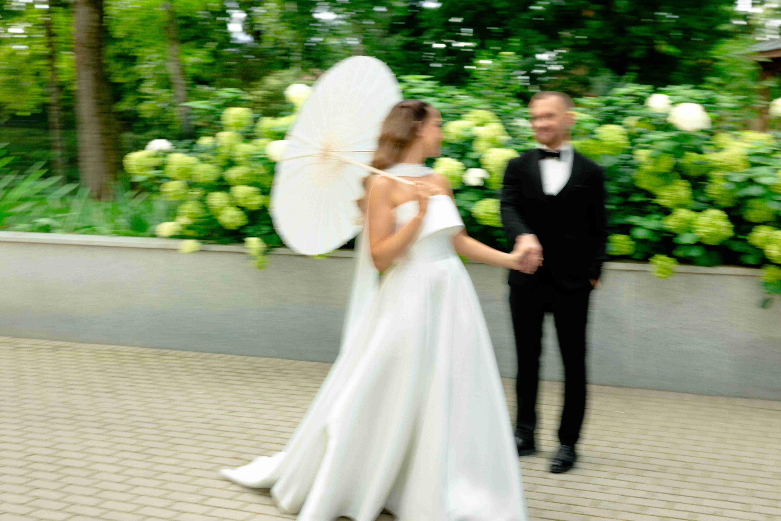 blurry image of newlyweds wandering in botanic garden