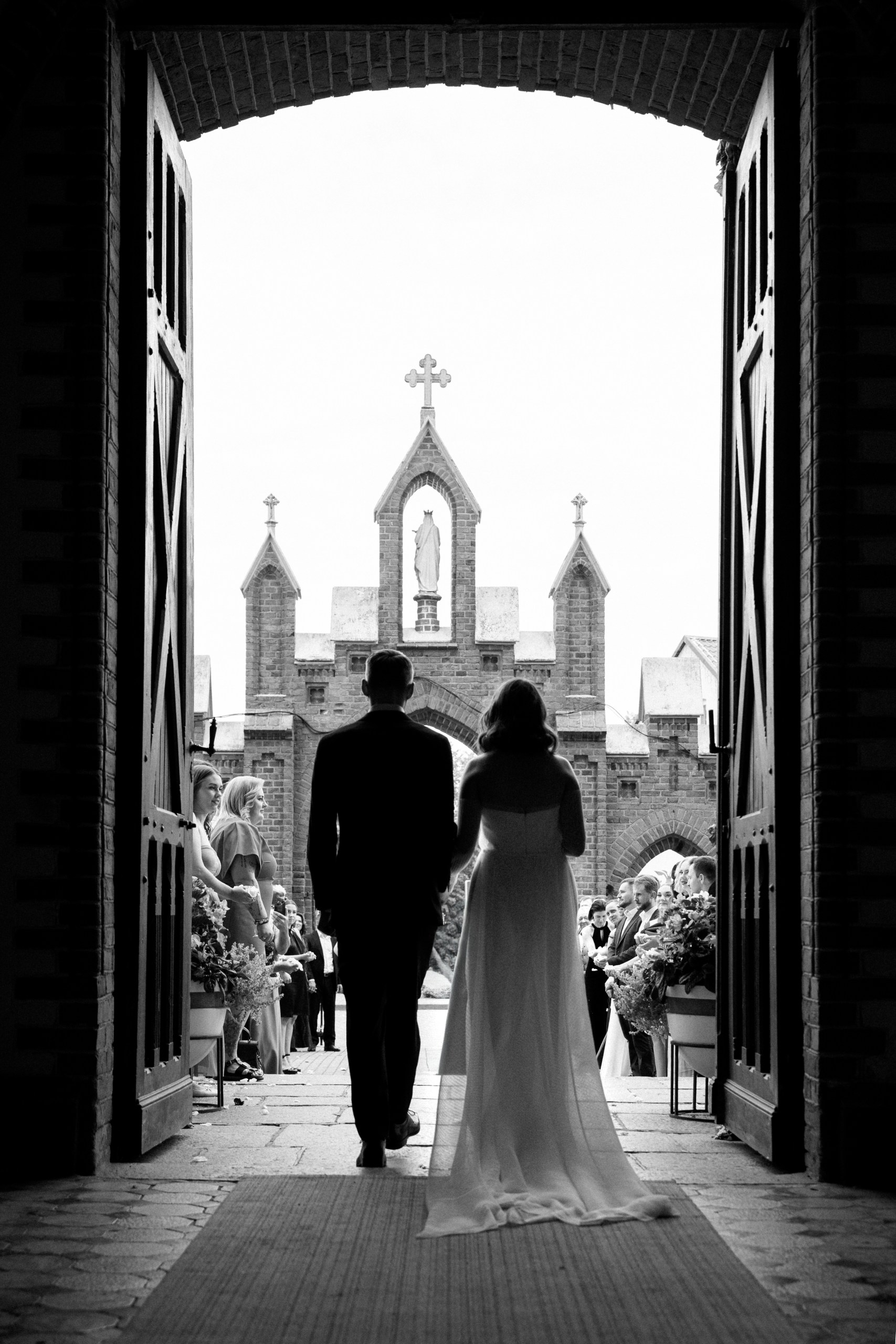 newlyweds walking from church švėkšnos šv jokūbo bažnyčia
