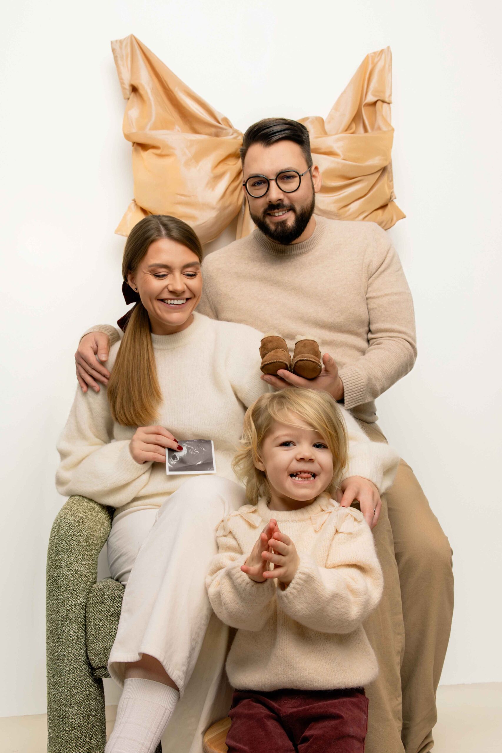 pregnancy family photoshoot with small child sister in minimalistic studio