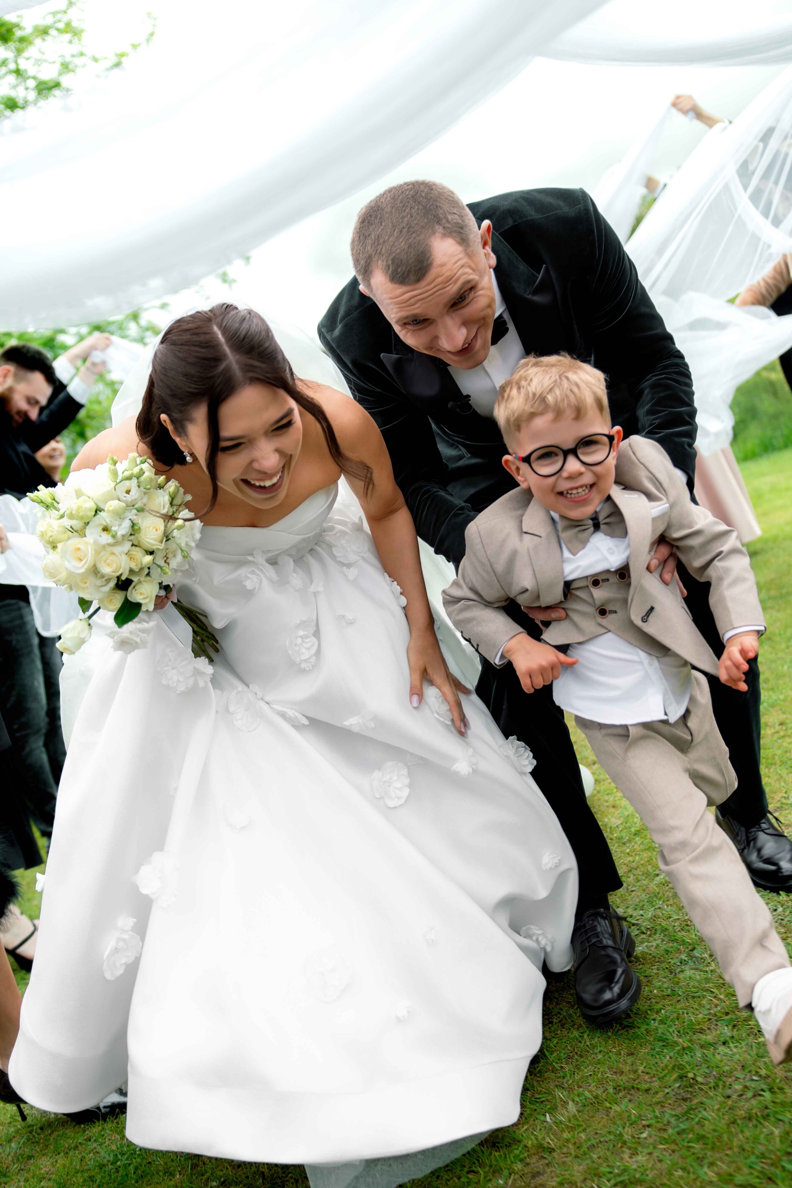 wedding ceremony going through white ribbons that guests hold