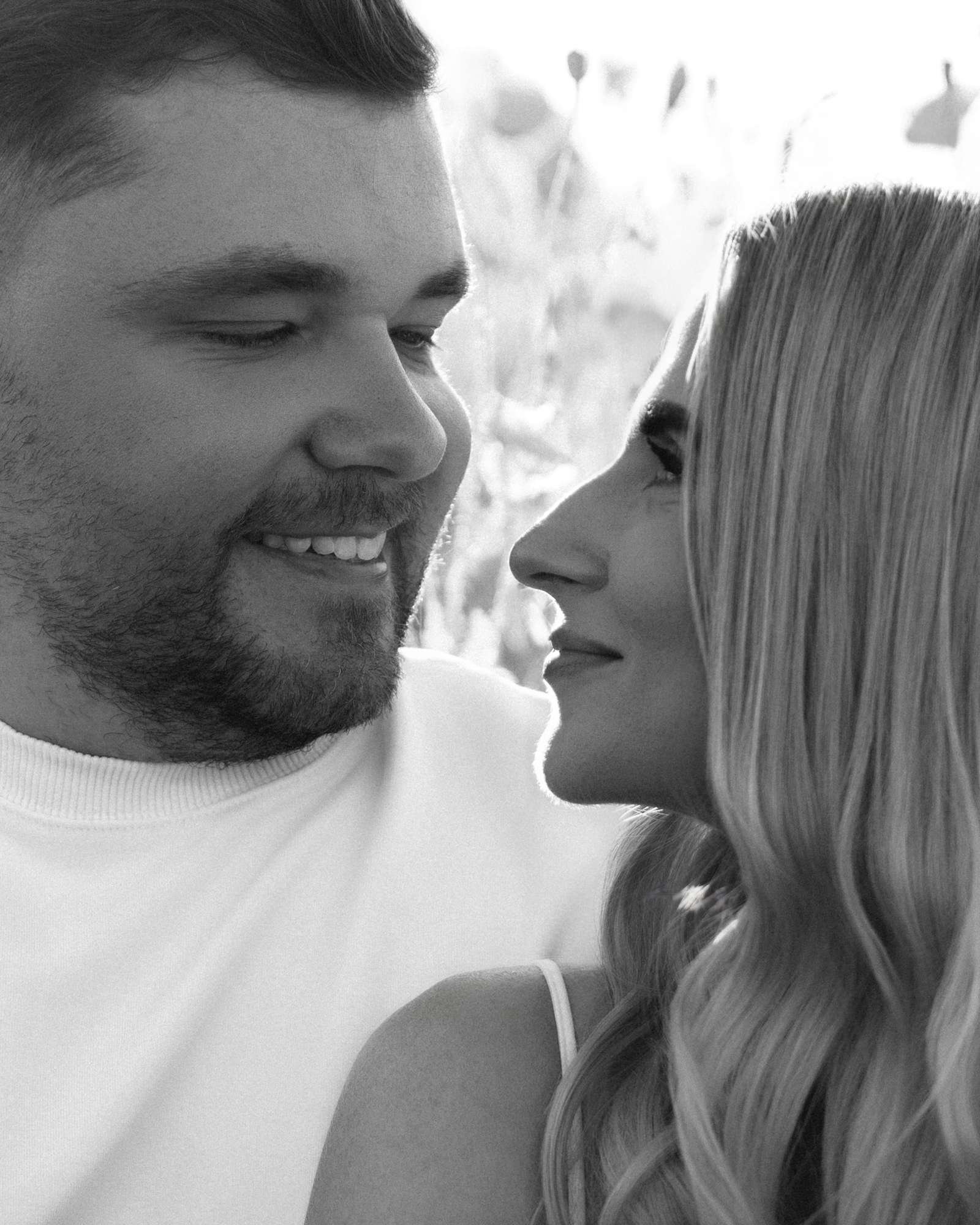 Black and white close up of a couple about to kiss, foreheads almost touching
