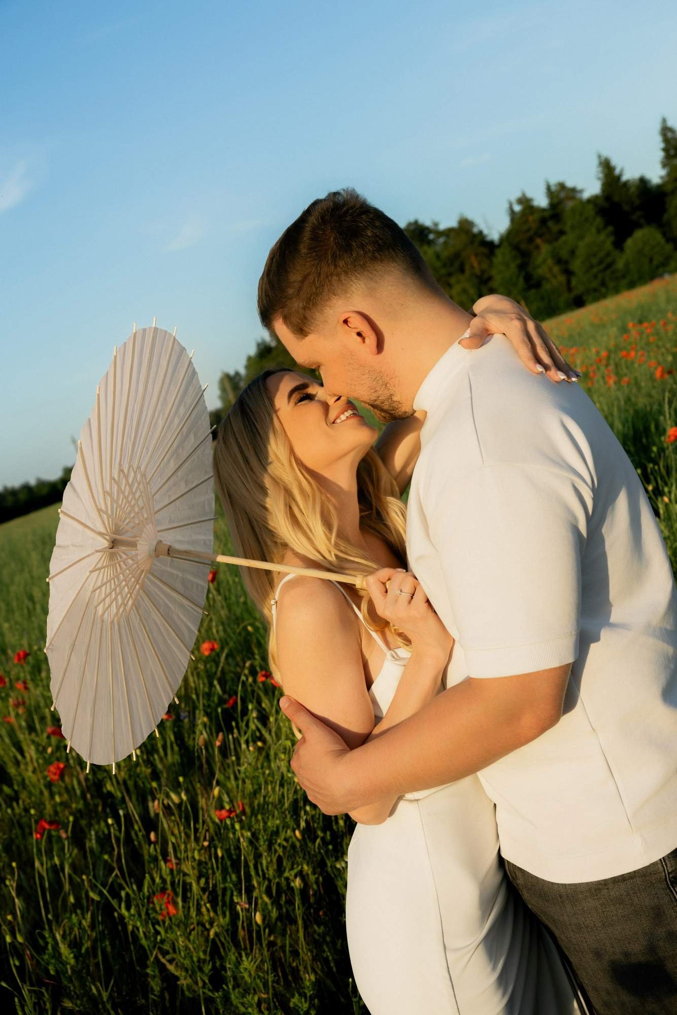 Couple kissing under a white paper parasol