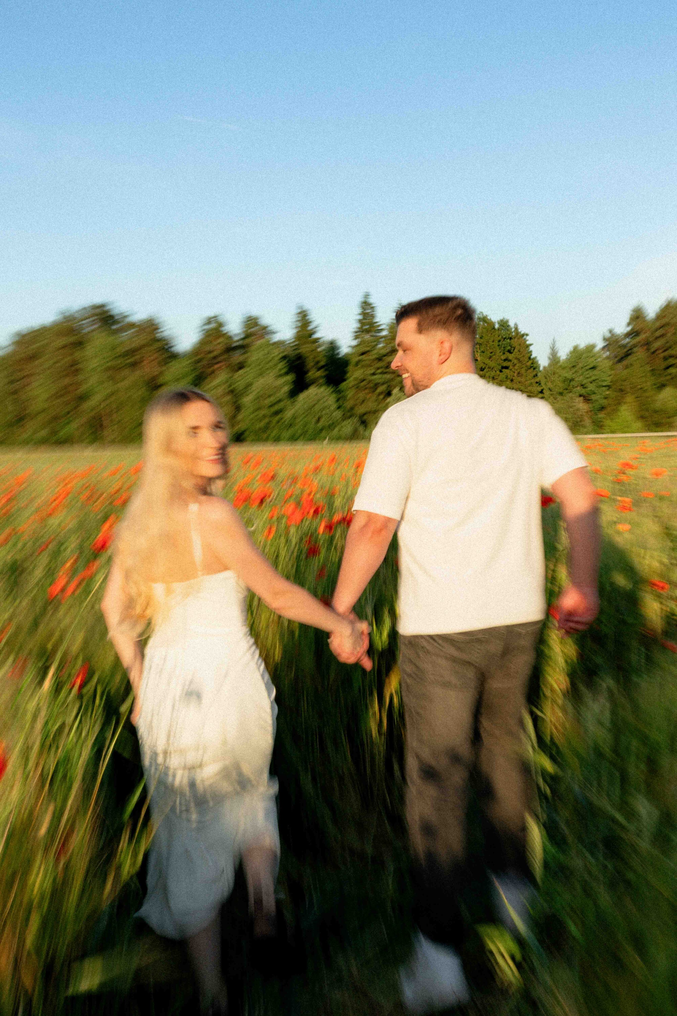couple running through flower field blurry motion