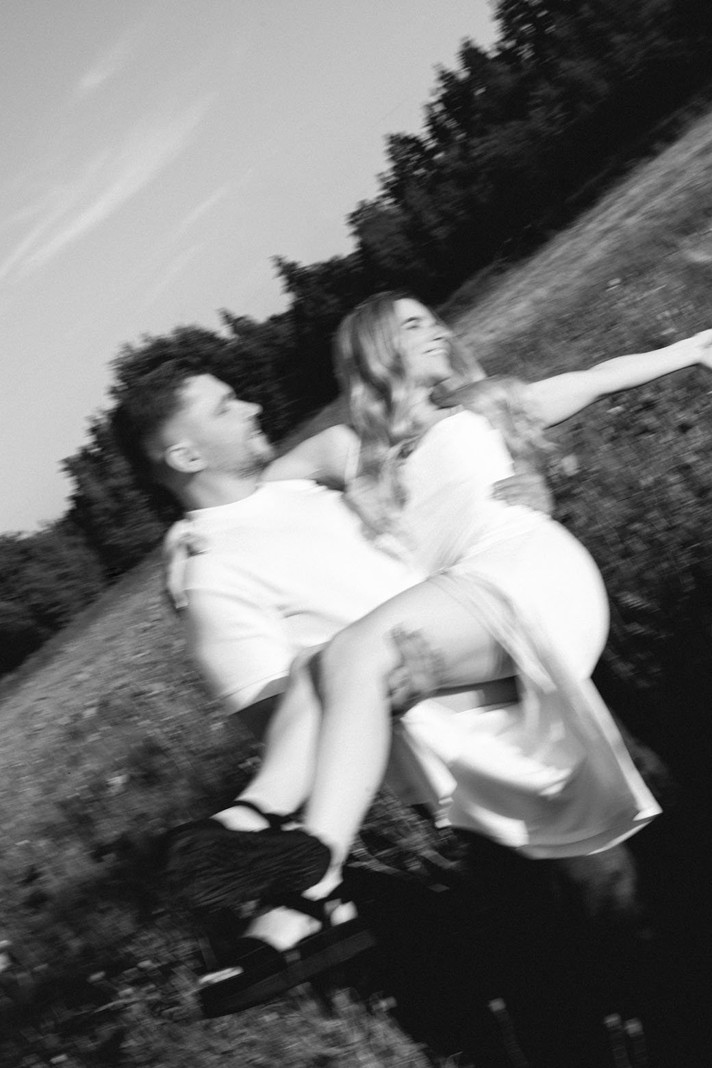 Couple spinning together in a rye field during golden hour