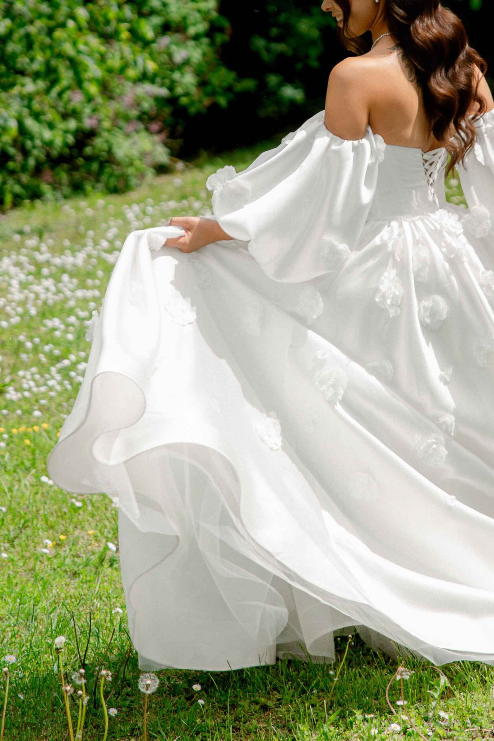 bride details shot dress with small flowers in nature