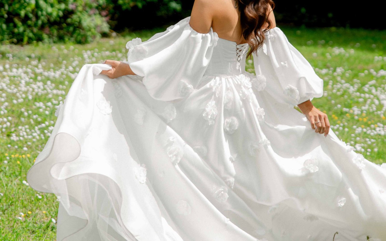 romantic wedding dress with flowers in white flowers field