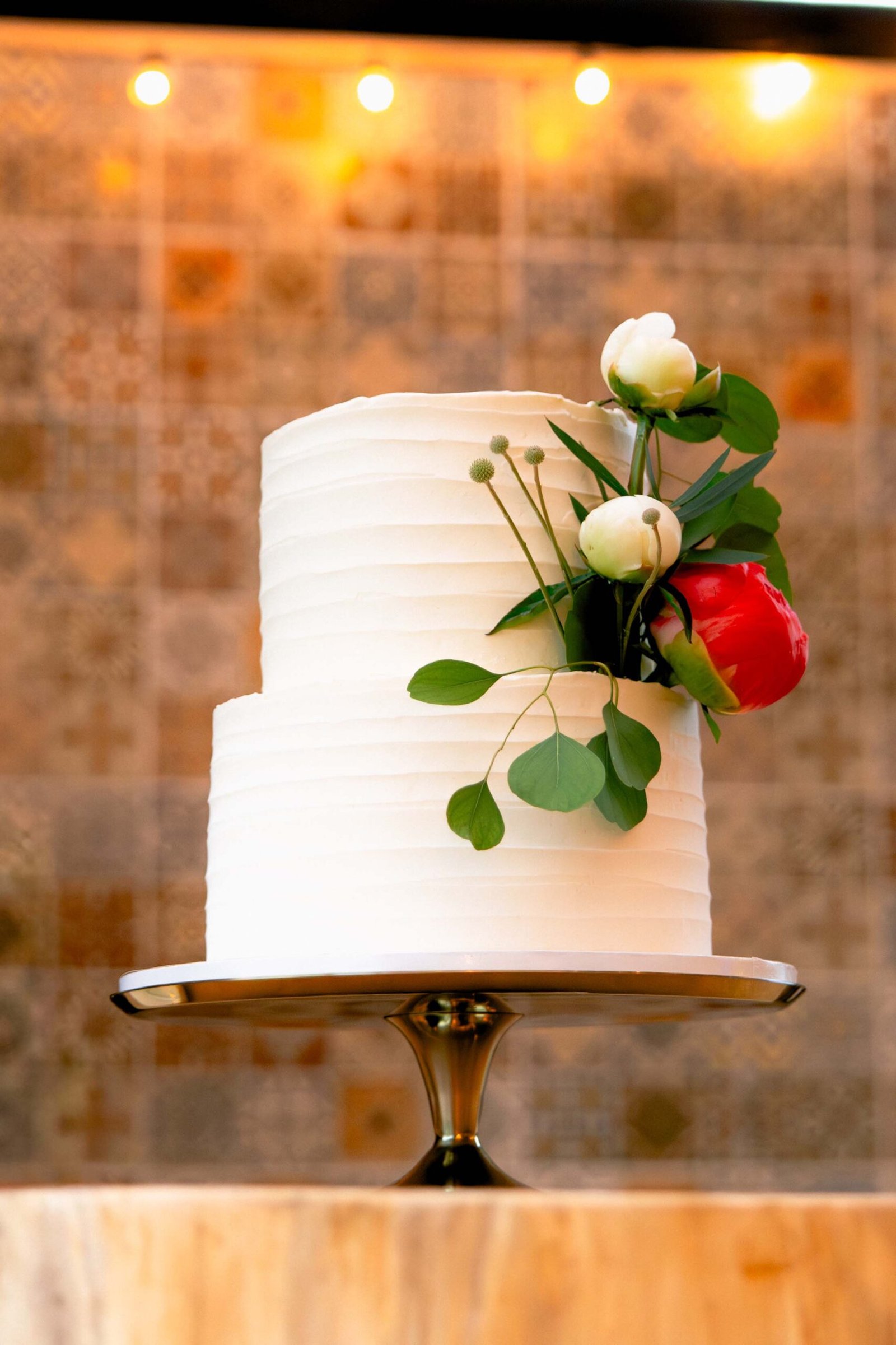 wedding cake with peonies on table