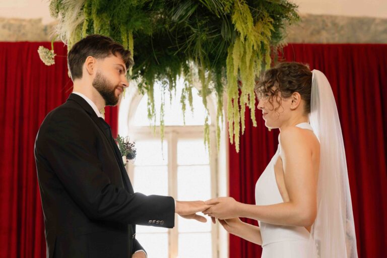 wedding ceremony exchancing rings burgundy backdrop