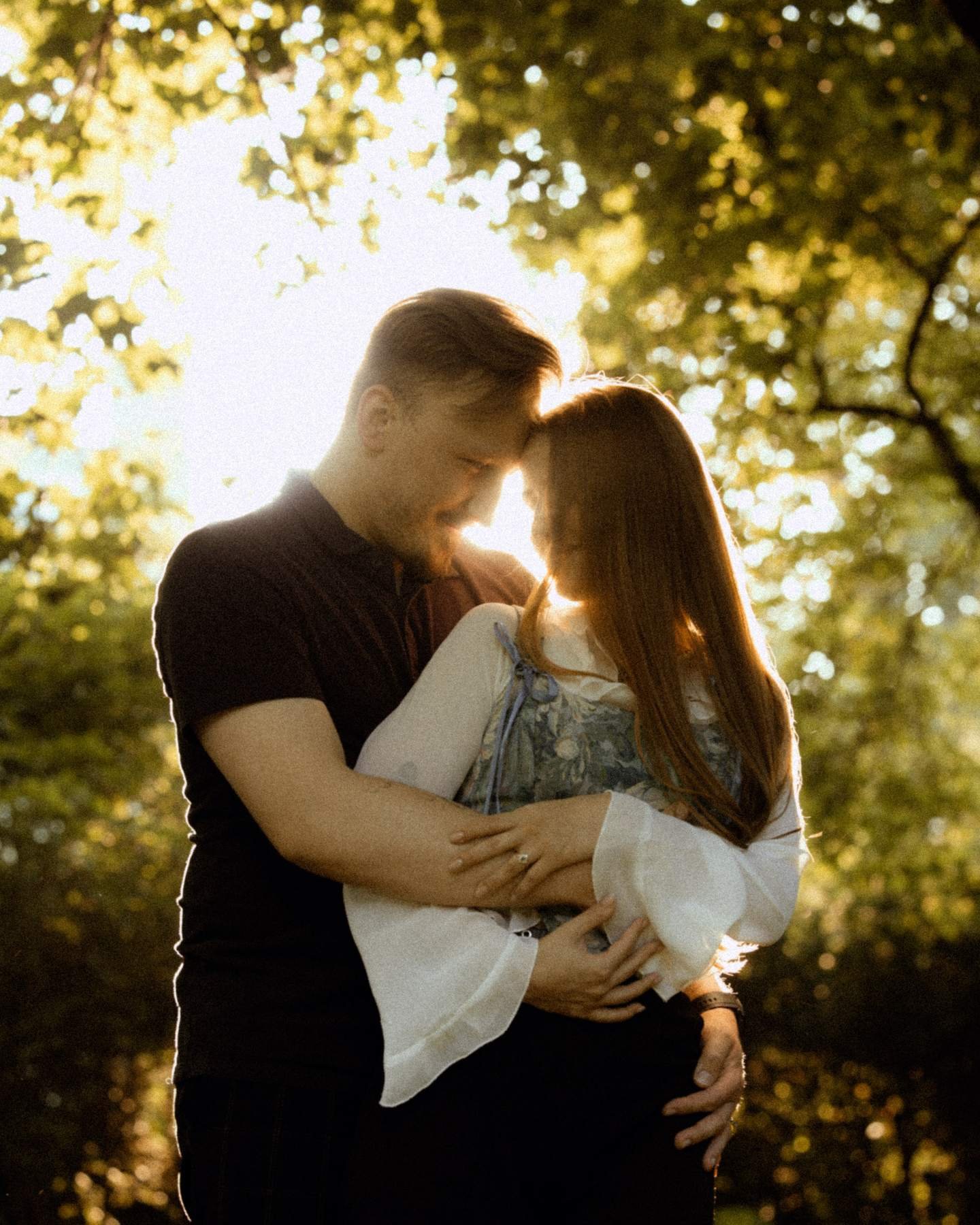Evaldas and Brigita touching foreheads in warm golden hour light.