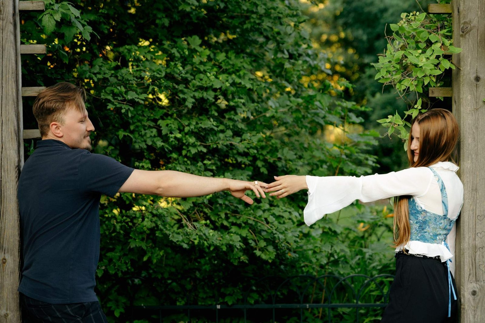 Color close-up of the couple reaching for each other's hands on the garden path.