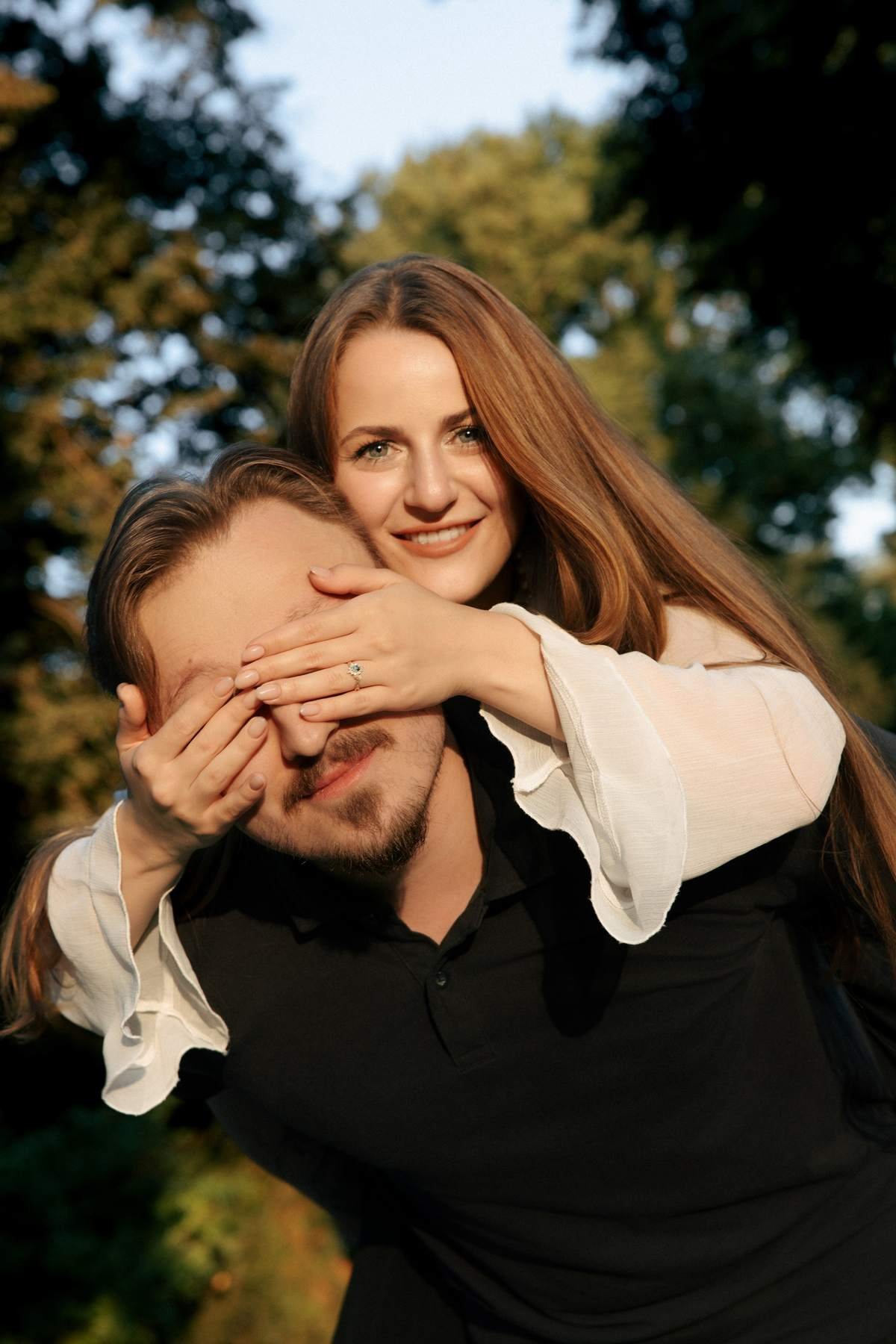 Laughing couple portrait with Brigita's hands playfully covering Evaldas's eyes.