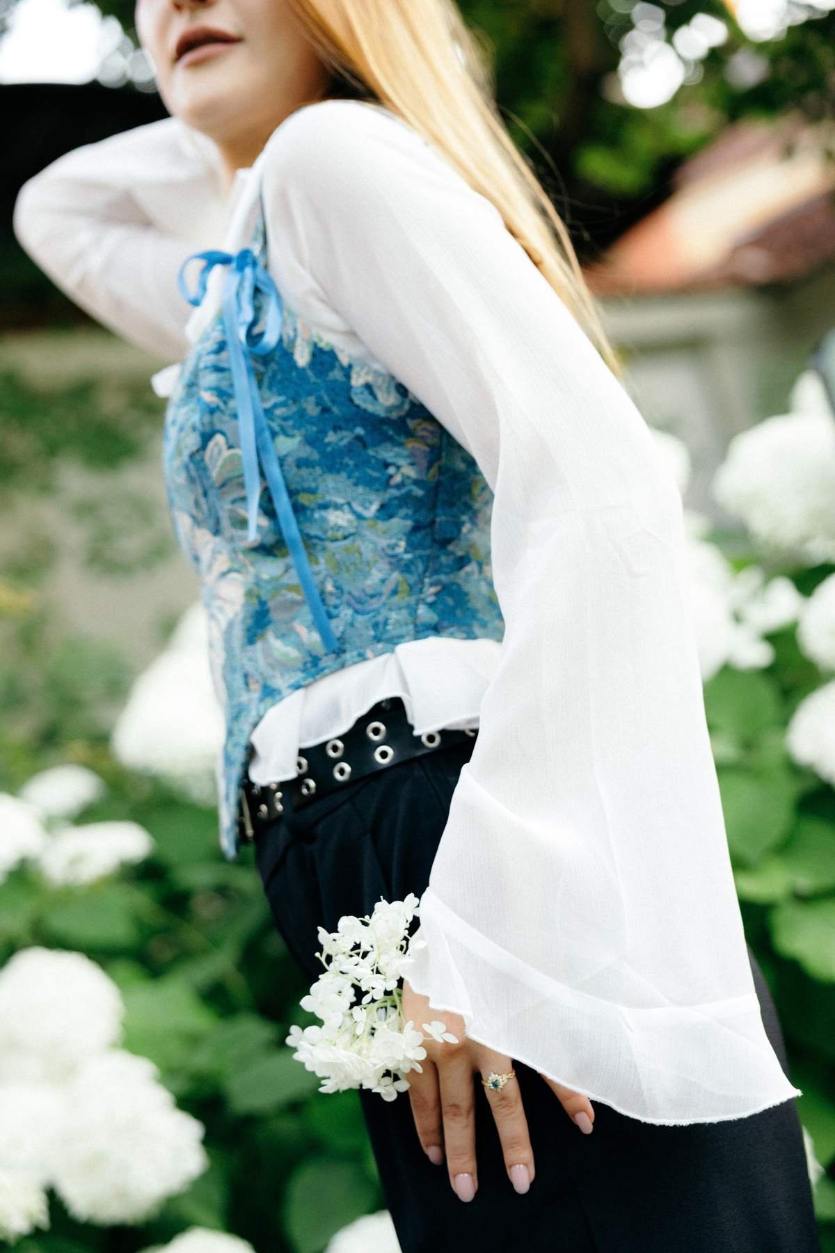 Side profile portrait of Brigita among the hydrangea blooms.