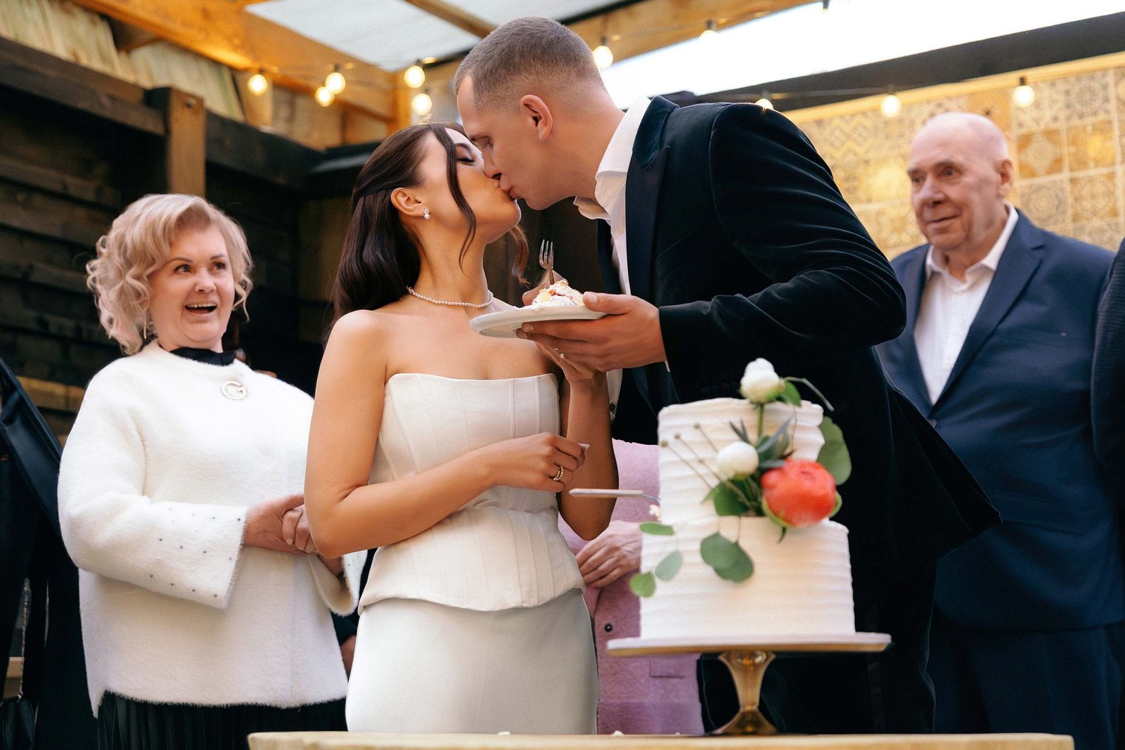 wedding cutting cake grandparents in background