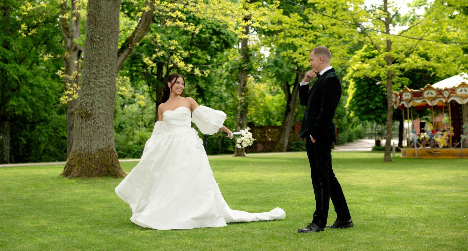 Bride and groom on a green lawn by the river